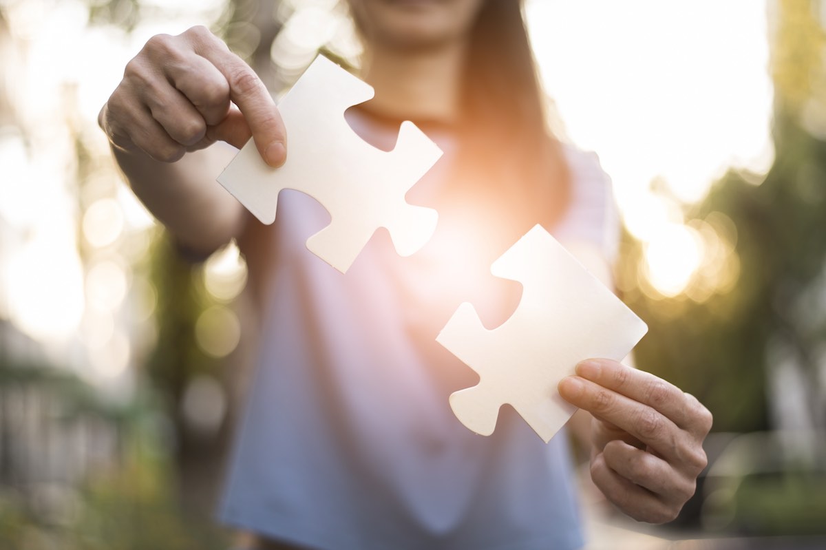 Eine Frau hält zwei Puzzleteile